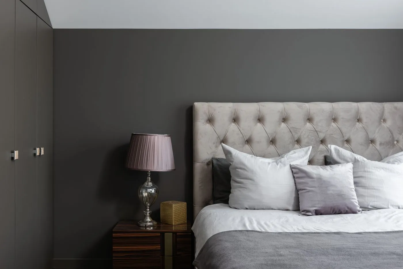 Modern bedroom with cushions and a bedside lamp