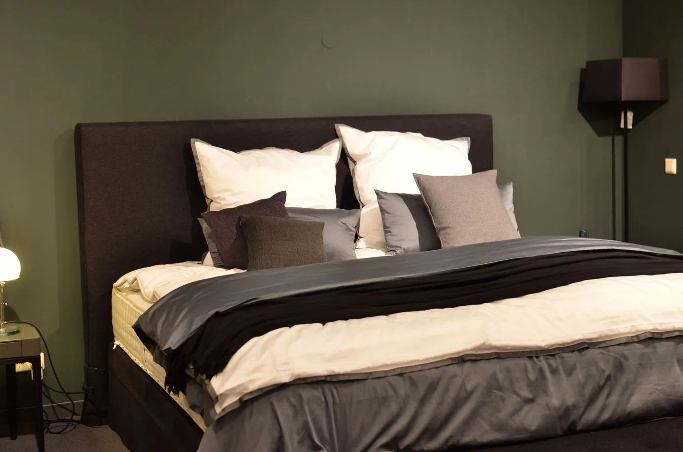 Bedroom with layered pillows and dark decor