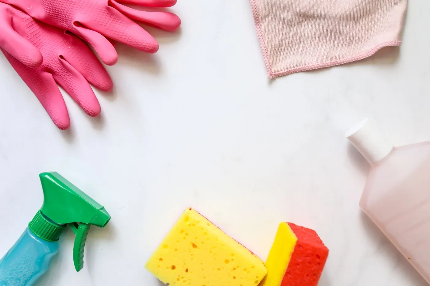 Cleaning cloths gloves and bottles on a household surface
