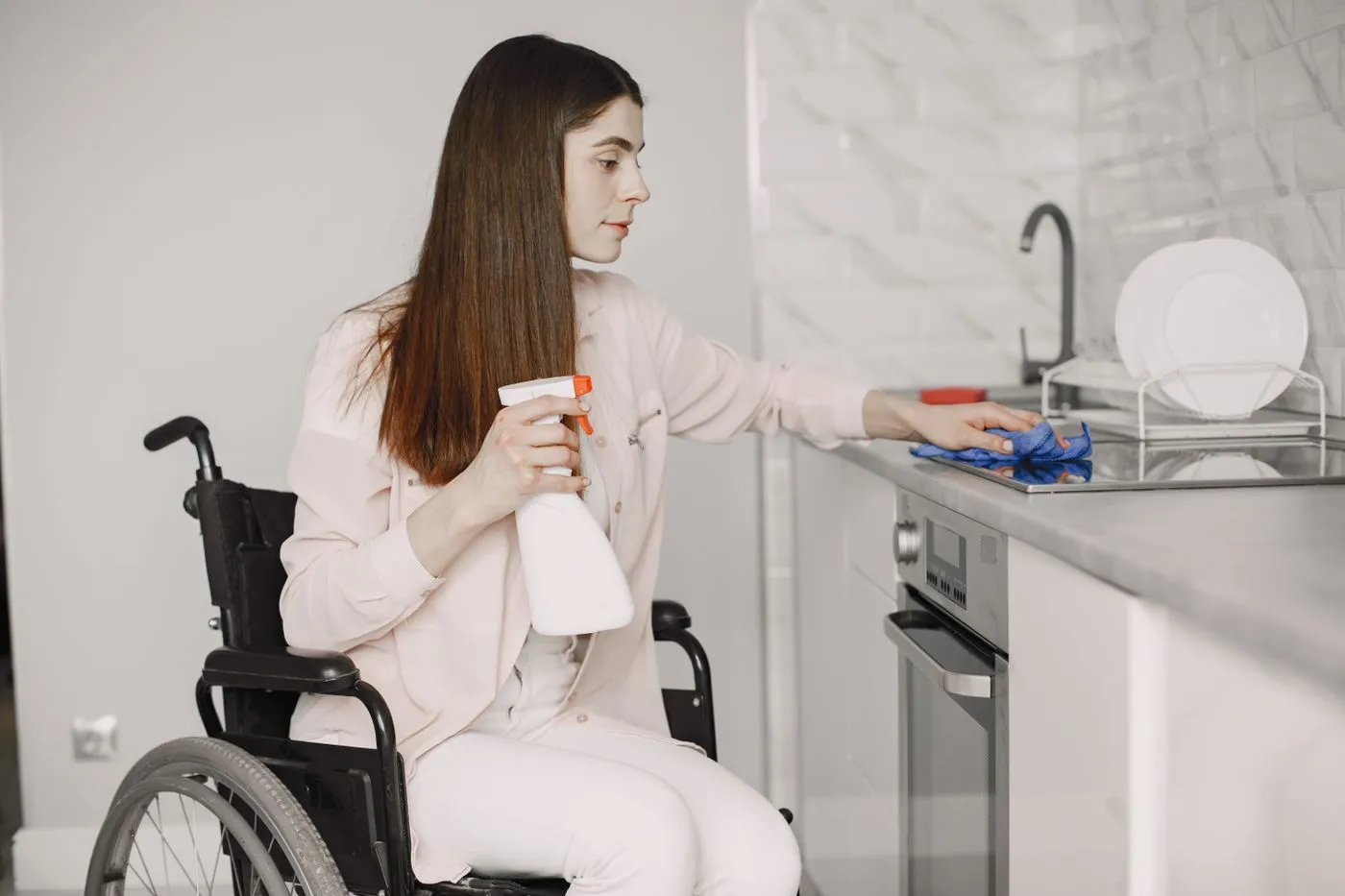 Person wiping a kitchen counter with a cloth