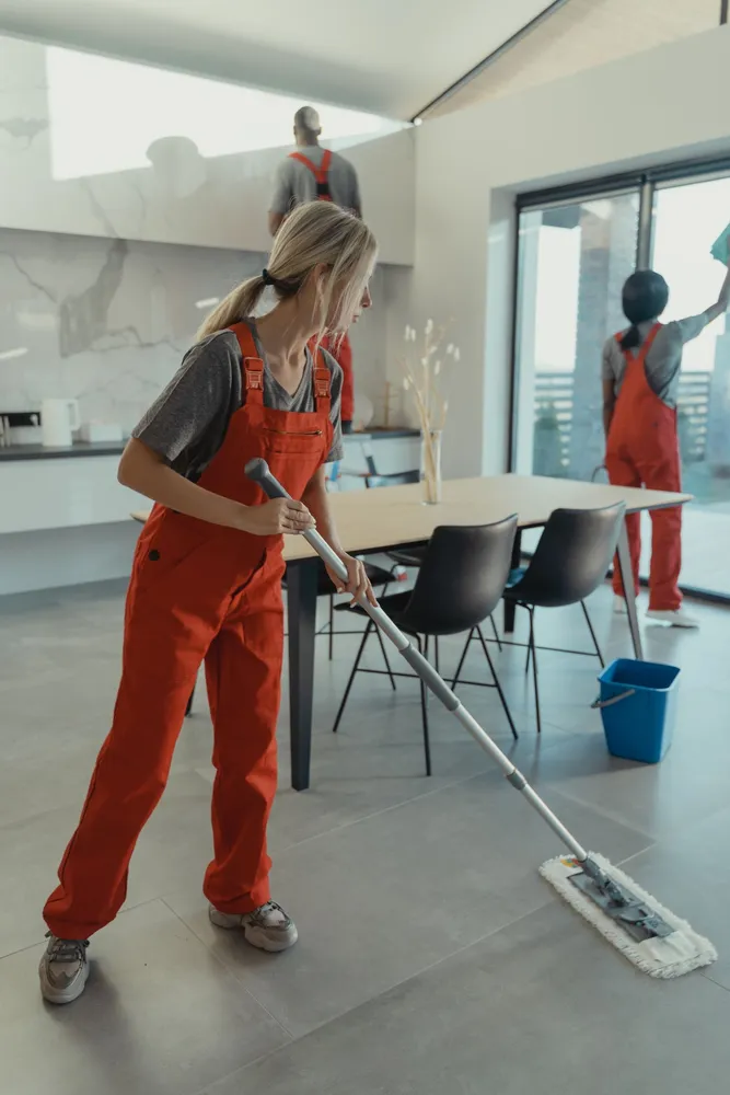 Cleaning workers using a mop inside a home