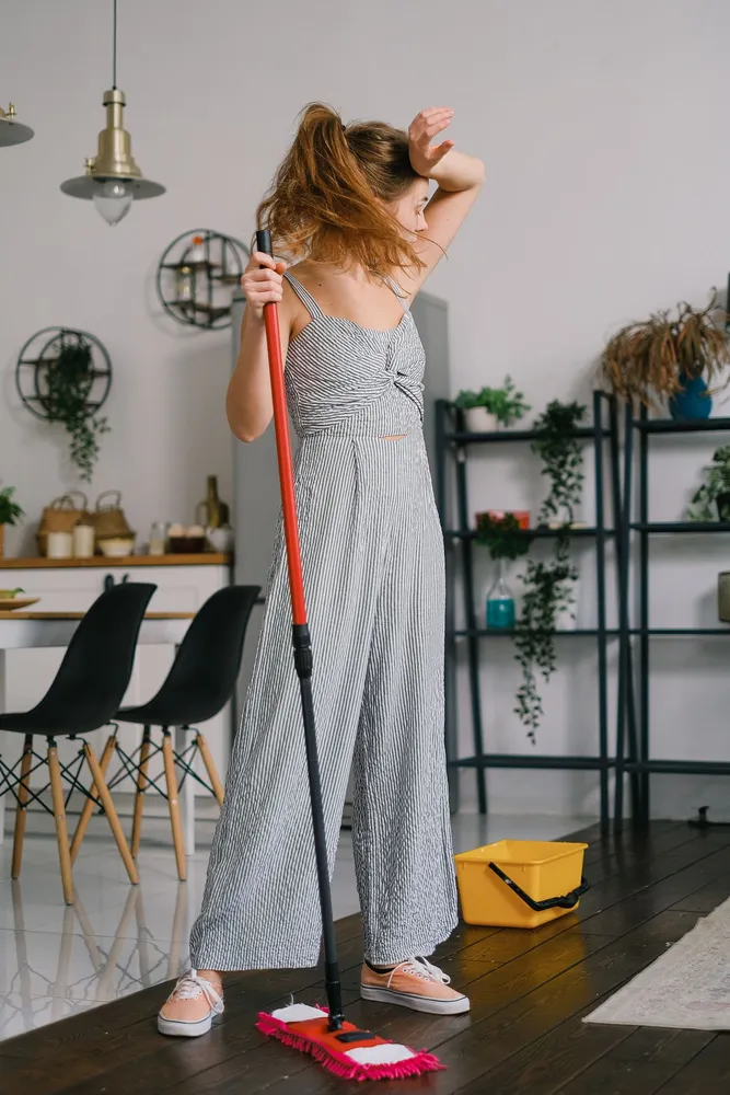 Person taking a break while mopping a wooden floor