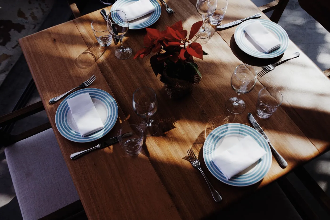 Plates glasses and flowers arranged on a dining table