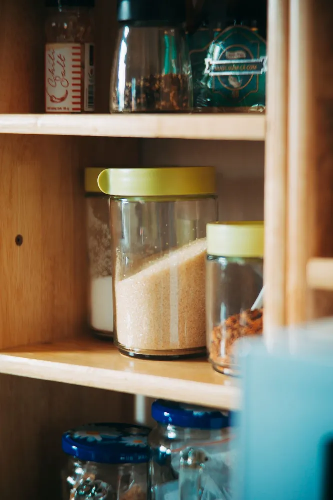 Pantry ingredients in glass jars on wooden shelves