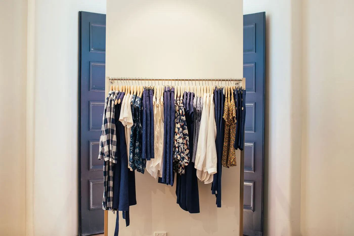 Clothes arranged on hangers along a wardrobe rack